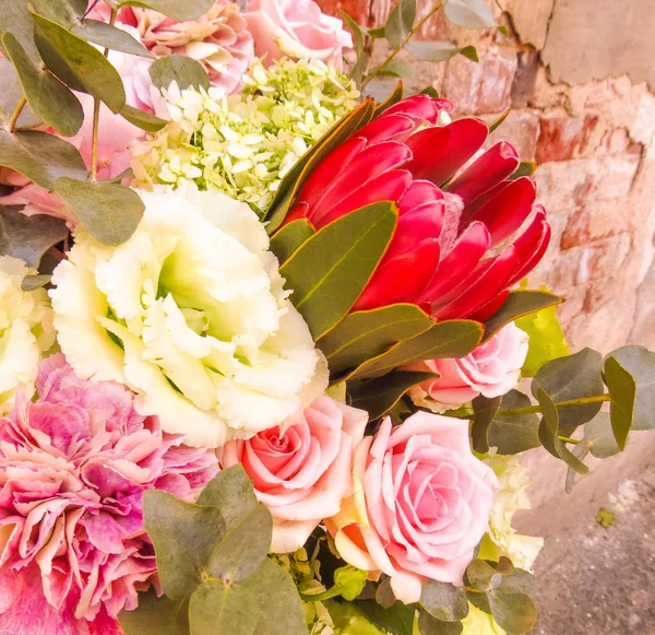 Bir buket ile protein yakın çekim. Şık yaz buket gül, karanfil, eustoma ve egzotik çiçekler. Çiçekçinin iş