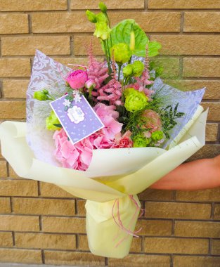 Bir çiçekçi bir çiçekçi dükkanı - parlak bir buket bir tebrik kartı ile çalışma