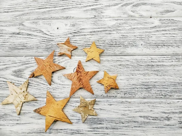 Wooden stars on a white vintage background. Beautiful idea for a Christmas template or background. Flat design hand-made stars close-up on wooden white background