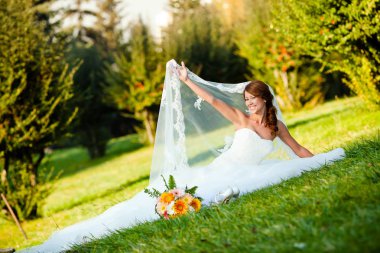 mutlu gelin parkta çim üzerinde oturan