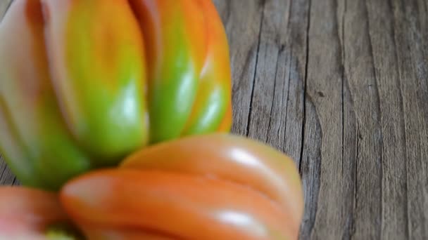 木製の背景に牛囲炉裏と呼ばれる生のトマトを閉じる — ストック動画