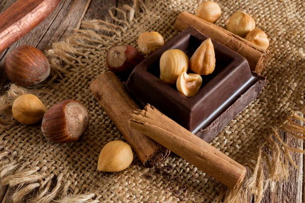 Bloco Chocolate Avelãs Descascadas Canela Saco Juta Mesa Madeira — Fotografia de Stock
