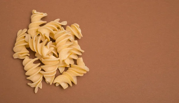 Giant Fusilli pasta på brun bakgrund — Stockfoto