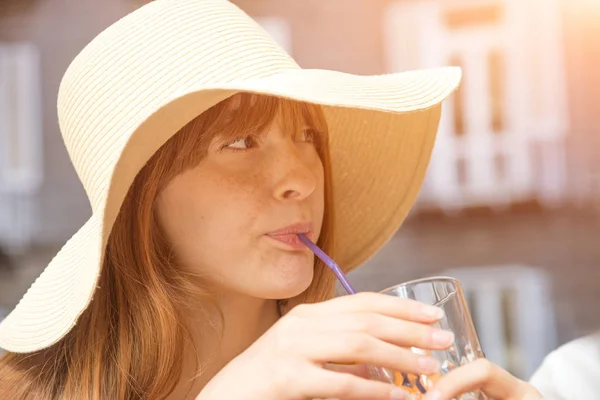 Young pretty girl with hat drinks an aperitif — Stock Photo, Image