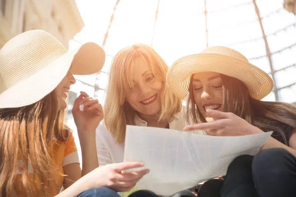 Three female tourists consult the city map — Stock Photo, Image