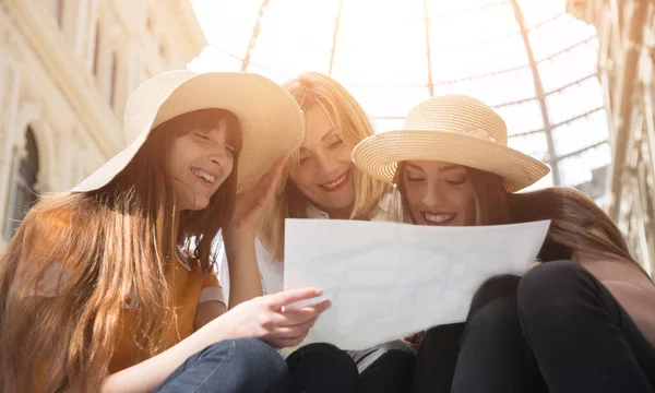 Three female tourists consult the city map — Stock Photo, Image