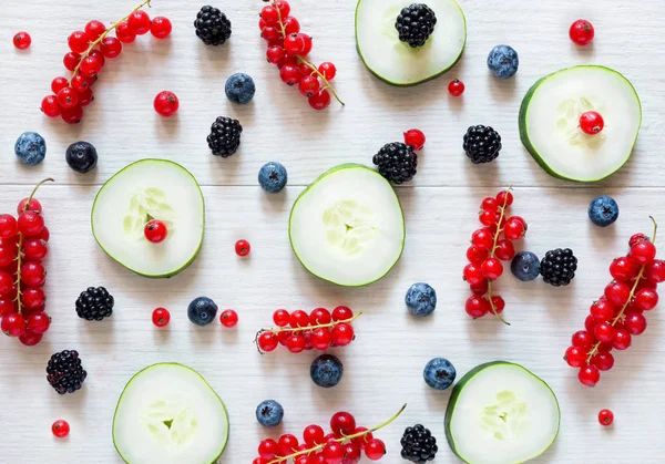 Food background with sliced cucumber and varius berries — Stock Photo, Image