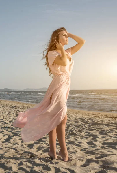 Jovem menina bonita na praia ao pôr do sol Imagens Royalty-Free