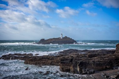Büyük dalgalar Godrevy St Ives, Cornwall, İngiltere 2 Mart 2016'de çekilen deniz feneri üzerine çökmesini ile dramatik fırtınalı denizde