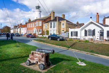 Southwold, Suffolk, İngiltere 26 Ekim 2018'de ön planda topuyla Southwold'ın ikonik feneri arkasında gördüm evler