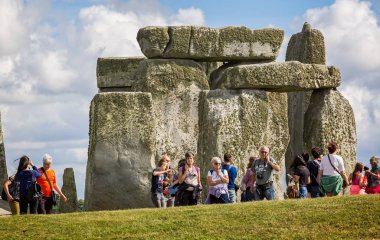 Stonehenge ve turistlerin Stonehenge, Wiltshire, İngiltere'de 13 Ağustos 2016 üzerinde kulaklık dinlerken yakın çekim