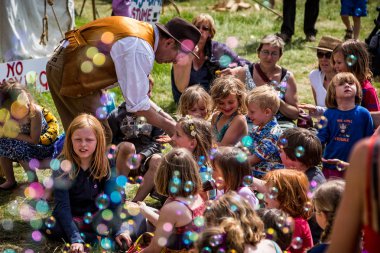 Grup kabarcıkları ile güneşin doğuşunu Chapmanslade, Wiltshire, İngiltere 2 Haziran 2013'de Festivali, ağırladı oturan genç çocuk
