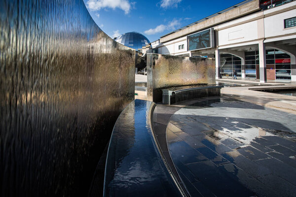 Water cascading down silver walled water feature in Millennium Square, Bristol, Somerset, UK on 24 February 2015