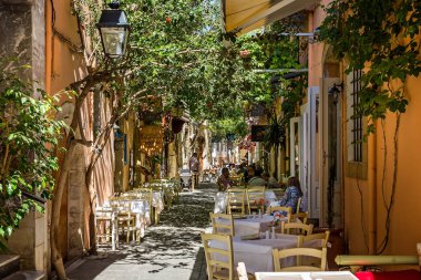 Yunanistan 'ın Girit kentinde 7 Mayıs 2016' da dar sokaktaki açık kafelerde bulunan restoranlar
