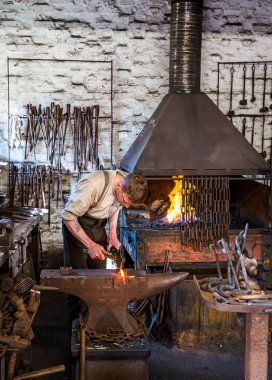 Demirci 10 Nisan 2019 'da Telford, Shropshire, İngiltere yakınlarında demir ocağı ve örsle birlikte çalışıyor.