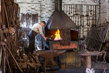 Demirci 10 Nisan 2019 'da Telford, Shropshire, İngiltere yakınlarında demir ocağı ve örsle birlikte çalışıyor.