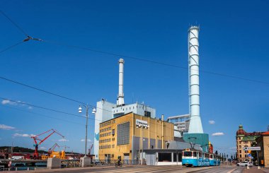 Göteborg elektrik santrali ve arka planında mavi tramvay bulunan bacalar 26 Temmuz 2019 tarihinde İsveç 'in Göteborg kentinde kurulmuştur.