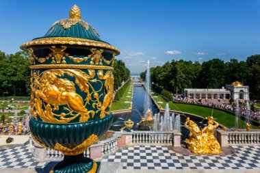 22 Temmuz 2019 'da Petergof, St Petersburg, Rusya' daki Peterhof Sarayı 'nın önündeki Büyük Şelale ve Samson çeşmelerinin önündeki dev süslemeli yeşil ve altın vazo.