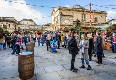 13 Aralık 2019 'da Bath Noel Pazarı, Bath, Somerset, İngiltere' deki Bath Abbey yakınlarında pazar tezgahları ve Roma hamamları