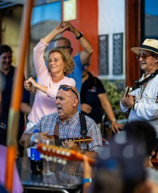 23 Kasım 2019 'da Garachico, Tenerife, İspanya' da bir barın önünde ukelele çalıp tutkuyla şarkı söyleyen müzisyenlere yakın çekim