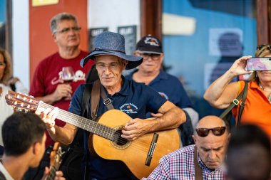 23 Kasım 2019 'da Tenerife, Garachico' da bir barın önünde gitar çalan olgun bir erkek müzisyenin yakın çekimi.