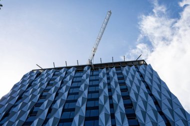 24 Ekim 2019 'da Perth, WA, Avustralya' da vinçle gökdelenin tepesine manevra yapılan büyük cam pencere.