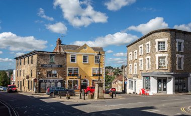 30 Ağustos 2020 'de Wincanton, Somerset, İngiltere' deki High Street ve Market Place kavşağındaki dükkanlar ve süslü lamba direkleri