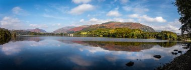 Panoramic view of Grasmere Lake with reflections  in The Lake District from the shore side in Cumbria, UK clipart