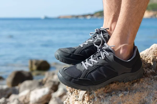 Hiking shoes on rocks, in the background you can see the sea