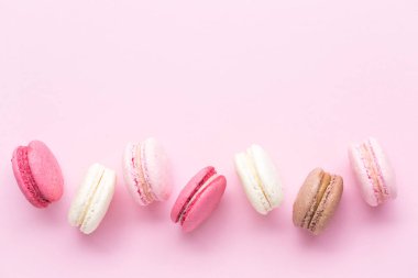Renkli pasta macaron veya pastel pembe arka plan üzerinde izole acıbadem kurabiyesi. Üstten görünüm.