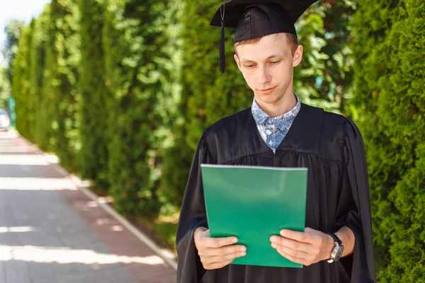 Erfolgreicher Absolvent Akademischen Kleidern Beim Abschluss Posiert Eine Grüne Mappe — Stockfoto