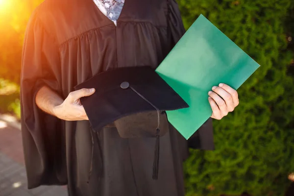 Успішний Аспірант Академічних Сукнях Випускних Позах Тримає Зелену Теку Дивиться — стокове фото