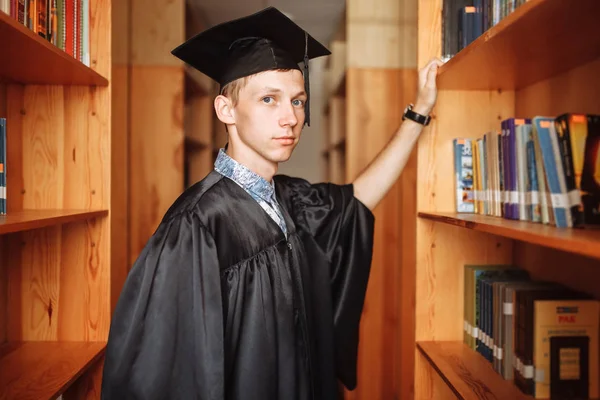 Erfolgreicher Absolvent Akademischer Kleidung Der Bibliothek Stehend Bücher Auswählend Kann — Stockfoto