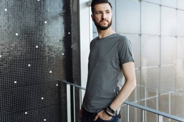 Biri siyah duvar arka cama yakın duran bir gri boş t-shirt giymiş güzel şık, yenilikçi, fotoğraf.