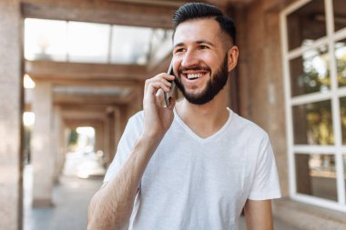 Arka cam bina planını telefonda konuşurken bir güzel şık adam portresi,