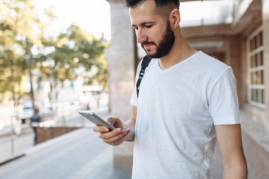Bina arka plan karşı sokakta telefon bakarak bir güzel şık adam portresi,