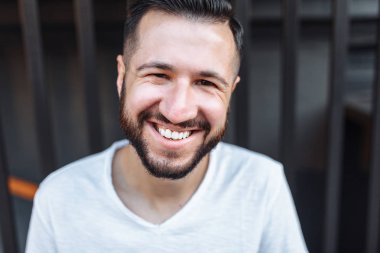 Şık hipster siyah çit arka plan üzerinde beyaz boş t-shirt giyen portresi