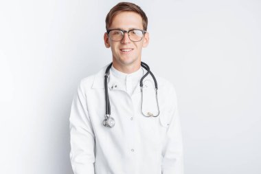 Beyaz bir arka planda stajyer stüdyoda genç bir doktor portresi