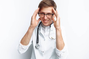 Baş ağrısı, stüdyo, stajyer stetoskop bir boyun ile gösteriyor beyaz bir arka plan üzerinde genç bir doktor portresi