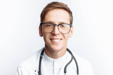 Beyaz bir arka planda stajyer stüdyoda genç bir doktor portresi