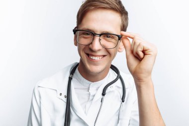 Beyaz bir arka planda stajyer stüdyoda genç bir doktor portresi