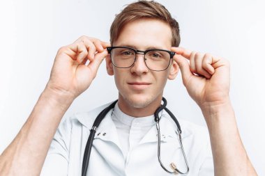 Beyaz bir arka planda stajyer stüdyoda genç bir doktor portresi