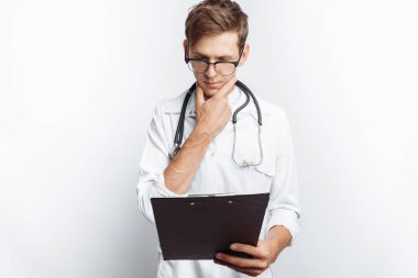 Düşünceli Doktor, beyaz bir arka plan üzerinde onun elinde bir klasörle genç bir öğrenci belgeleri ve belgelerdeki yapar notları bakarak,