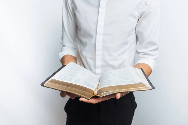 Man reading Bible, white background, book in hand close-up, isolated