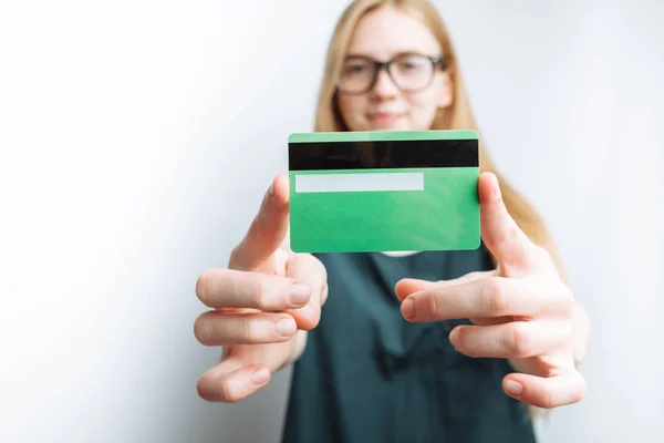 Beautiful girl shows Bank card, white background, advertising card