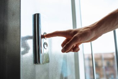 Asansörün düğmesine, düğme için izole Asansör, basma düğmesi Başlat ' için bekleyen kız ulaşan bir el başparmak presler