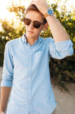 Sahilde, gün batımında, yenilikçi şık giysiler içinde poz poz güzel şık gözlüklü,,