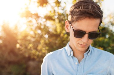 Sahilde, gün batımında, yenilikçi şık giysiler içinde poz poz güzel şık gözlüklü,,