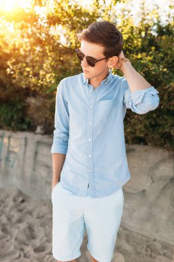 Sahilde, gün batımında, yenilikçi şık giysiler içinde poz poz güzel şık gözlüklü,,