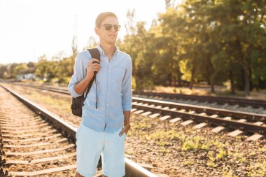 Gün batımı, yenilikçi şık giysiler içinde poz, tren rayları üzerinde poz güzel şık gözlüklü,,